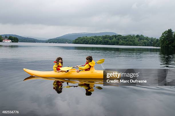 young boy and girl kayaking on a lake - kayaking canada stock pictures, royalty-free photos & images