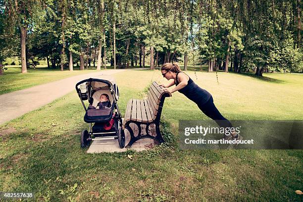 new mother doing exercises with baby sleeping in stroller. - three wheeled pushchair stock pictures, royalty-free photos & images