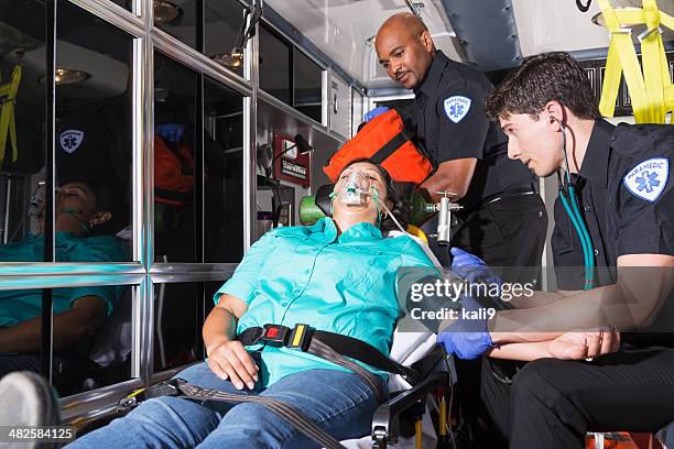 paramedics helping a patient - medical ambulance female stockfoto's en -beelden