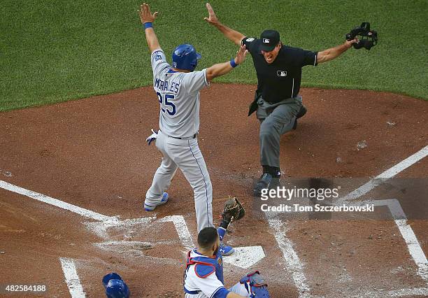 Kendrys Morales of the Kansas City Royals is called safe at home plate to score a run in the first inning during MLB game action as Russell Martin of...