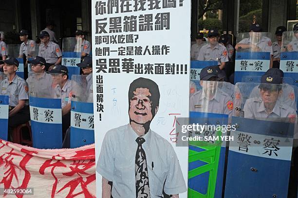 Placard placed by protesters of Taiwan's Education Minister Wu Se-hwa stands in front of policemen during a demonstration at the Education Ministry...