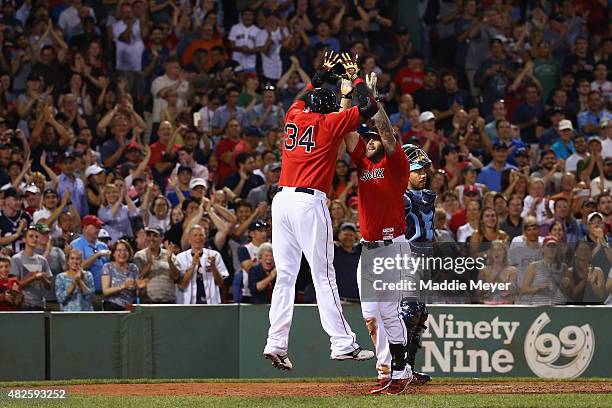 David Ortiz of the Boston Red Sox congratulates Mike Napoli after he hit a two run homer during the seventh inning against the Tampa Bay Rays at...