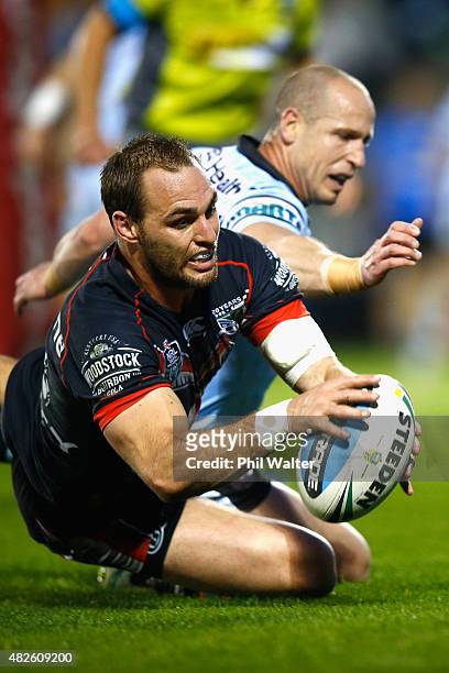 Simon Mannering of the Warriors scores a try under pressure from Jeff Robson of the Sharks during the round 21 NRL match between the New Zealand...