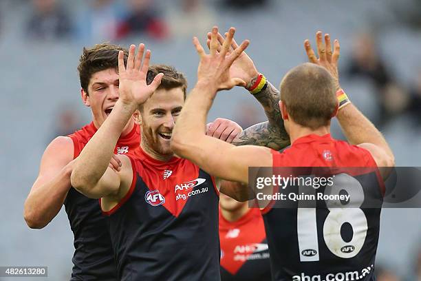 Jeremy Howe of the Demons is congratulated by Angus Brayshaw and Daniel Cross after kicking a goal during the round 18 AFL match between the...