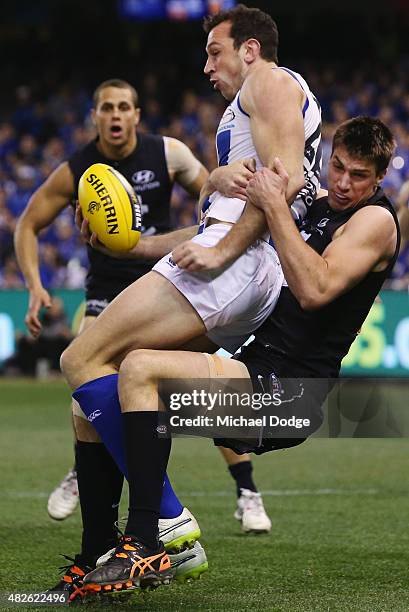 Matthew Kreuzer of the Blues tackles Todd Goldstein of the Kangaroos during the round 18 AFL match between the Carlton Blues and the North Melbourne...