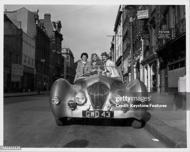 The Andrews Sisters posing for a photograph in a car; Maxene, Patty and LaVerne, London, 1948.