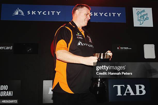 Craig Caldwell celebrates with the trophy after winning the Super League Darts Final between Warren Parry and Craig Caldwell at Sky City on August 1,...