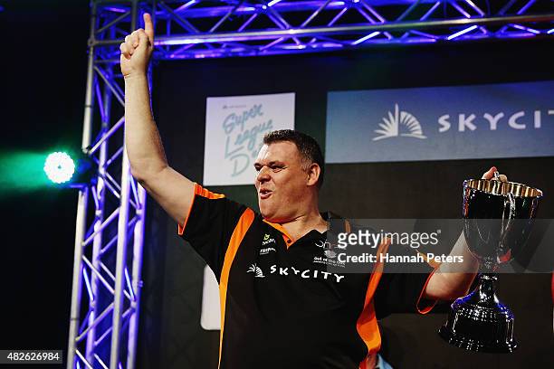 Craig Caldwell celebrates with the trophy after winning the Super League Darts Final between Warren Parry and Craig Caldwell at Sky City on August 1,...