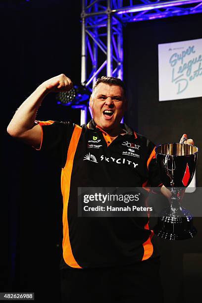 Craig Caldwell celebrates with the trophy after winning the Super League Darts Final between Warren Parry and Craig Caldwell at Sky City on August 1,...