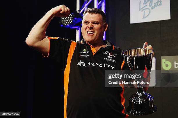 Craig Caldwell celebrates with the trophy after winning the Super League Darts Final between Warren Parry and Craig Caldwell at Sky City on August 1,...