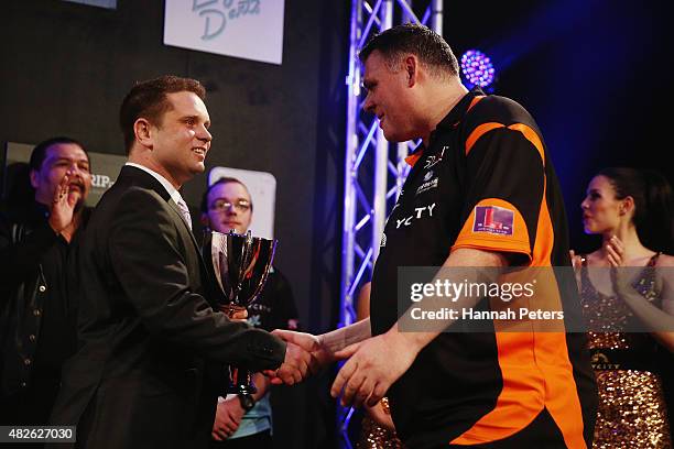 Craig Caldwell receives the trophy after winning the Super League Darts Final between Warren Parry and Craig Caldwell at Sky City on August 1, 2015...