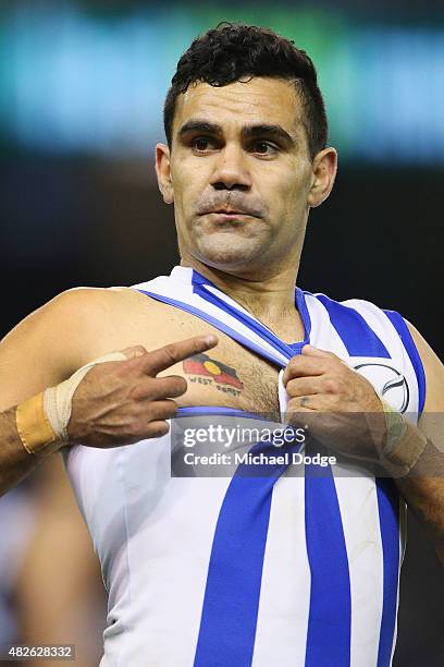 Lindsay Thomas of the Kangaroos celebrates a goal and points to his Aboriginal Flag tattoo during the round 18 AFL match between the Carlton Blues...