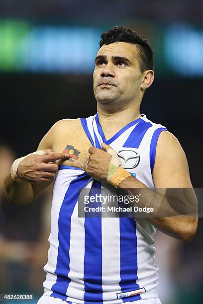 Lindsay Thomas of the Kangaroos celebrates a goal and points to his Aboriginal Flag tattoo during the round 18 AFL match between the Carlton Blues...