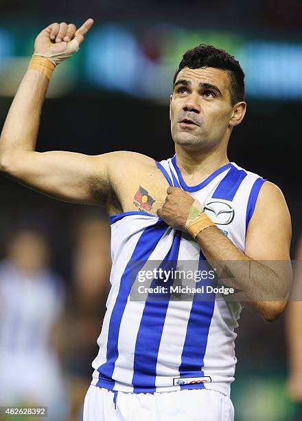 Lindsay Thomas of the Kangaroos celebrates a goal and points to his Aboriginal Flag tattoo during the round 18 AFL match between the Carlton Blues...