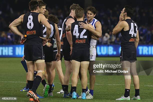 Jarrad Waite of the Kangaroos hugs former teamates as he celebrates the win in his 200th game during the round 18 AFL match between the Carlton Blues...