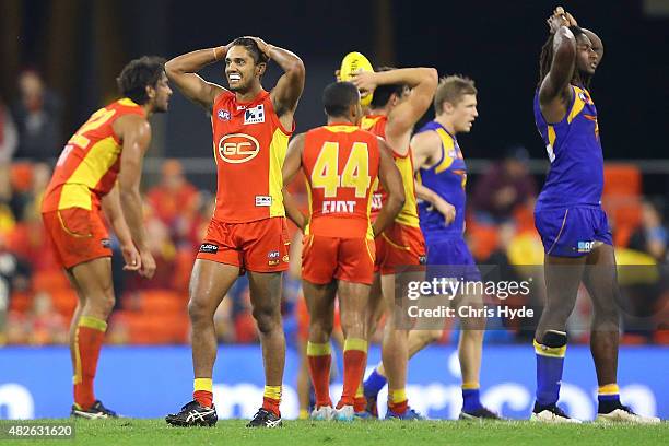 Aaron Hall of the Suns and Nic Naitanui of the Eagles react after a draw during the round 18 AFL match between the Gold Coast Suns and the West Coast...