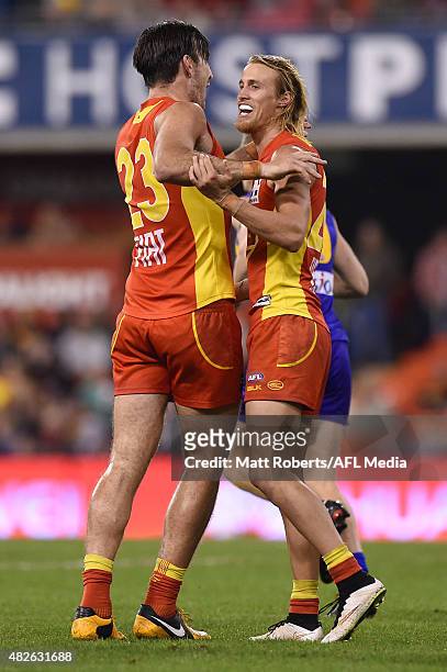 Charlie Dixon of the Suns celebrates kicking a goal with Matt Shaw during the round 18 AFL match between the Gold Coast Suns and the West Coast...
