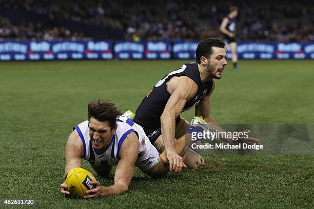 Jarrad Waite of the Kangaroos marks the ball against Simon White of the Blues during the round 18 AFL match between the Carlton Blues and the North...