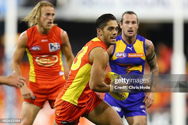 Aaron Hall of the Suns runs the ball during the round 18 AFL match between the Gold Coast Suns and the West Coast Eagles at Metricon Stadium on...