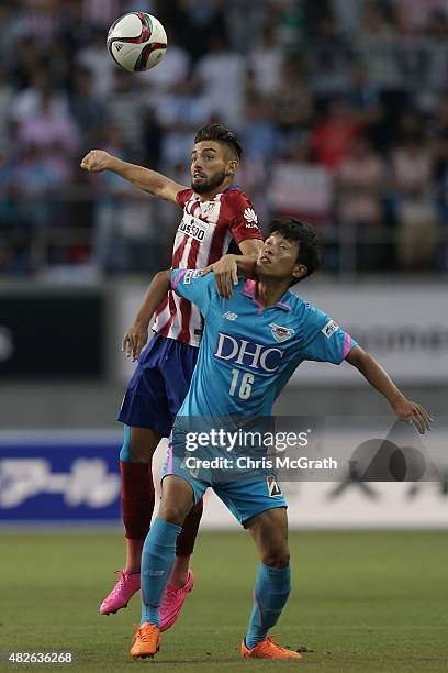 Yannick Carrasco of Atletico Madrid contests the ball with Choi Sung Keun of Sagan Tosu F.C. During the friendly match between Atletico Madrid and...