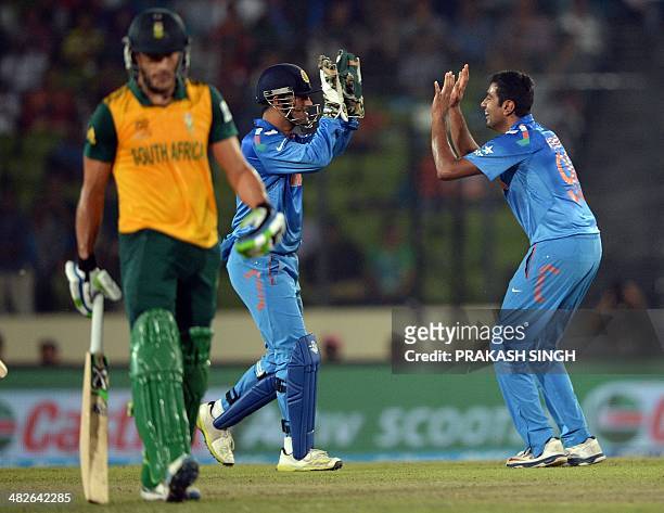 India bowler Ravichandran Ashwin celebrates the wicket of South Africa batsman Hashim Amla with captain Mahendra Singh Dhoni during the ICC World...