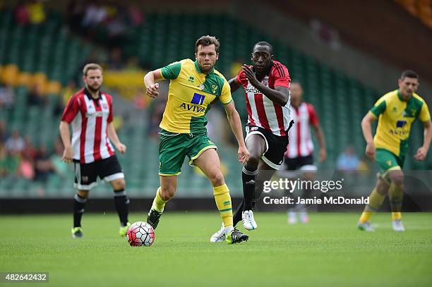 Jonny Howson of Norwich City battles with Toumani Diagouraga of Brentford during the pre season friendly match between Norwich City and Brentford at...