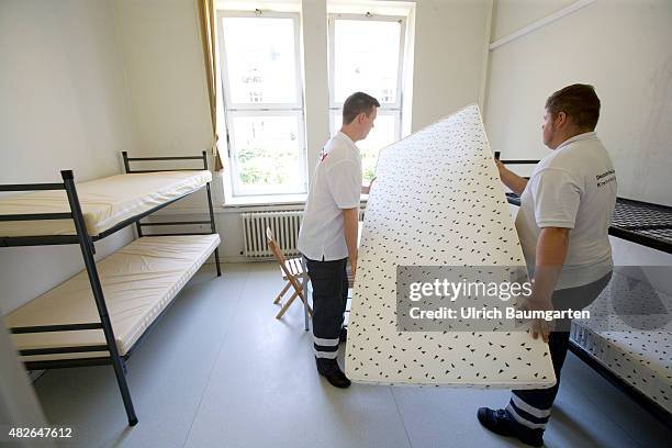 Arrival of refugees and asylum seekers in the Bonn Ermekeil barracks. Employees of the German Red Cross when building beds.