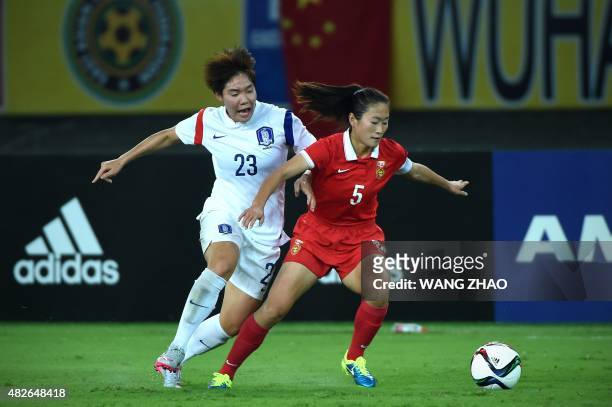 Wu Haiyan of China fights for the ball with Lee Geummin of South Korea during their women's East Asian Cup football match at the Wuhan Sports Center...