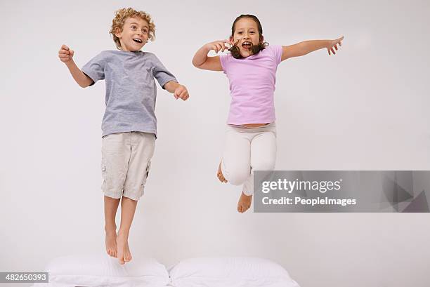 estoy más! - a boy jumping on a bed fotografías e imágenes de stock