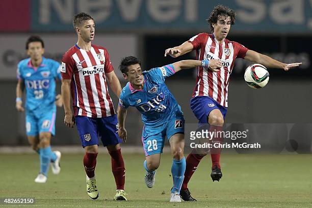Yoshiki Takahashi of Sagan Tosu contests the ball with Tiago Cardoso of Atletico Madrid during the friendly match between Atletico Madrid and Sagan...