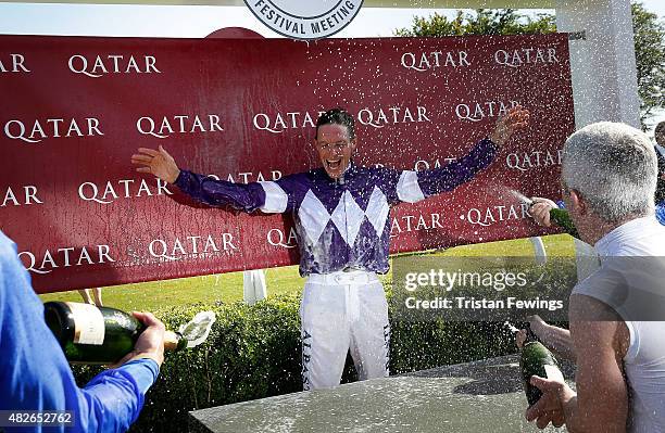 Retiring jockey Richard Hughes is sprayed with champagne on day five of the Qatar Goodwood Festival at Goodwood Racecourse on August 1, 2015 in...