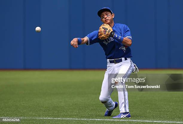 Munenori Kawasaki of the Toronto Blue Jays throws out the baserunner in the first inning during MLB game action against the Kansas City Royals on...