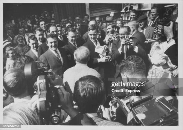 American pianist Liberace smiling and talking to the press as he leaves court, following his successful libel action against the Daily Mail over a...
