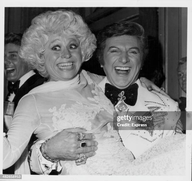 American pianist Liberace posing with British actress Barbara Windsor in his arms, at the London Palladium, England, April 27th 1978.