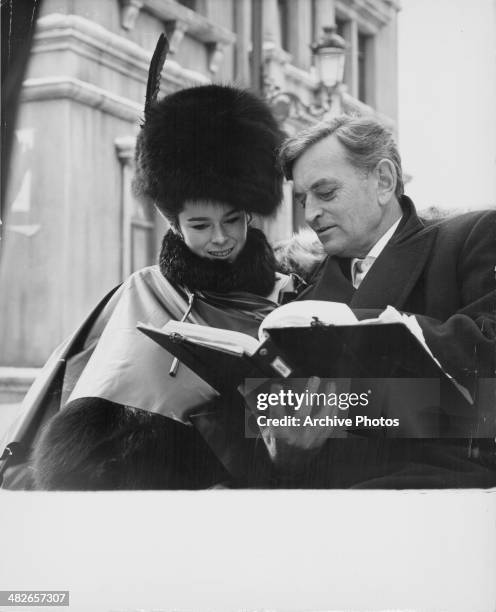 British director David Lean holding a binder and discussing a script with an actress, circa 1970.