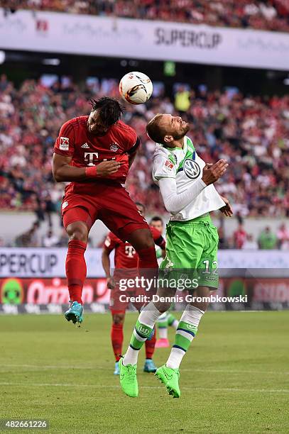 Medhi Benatia of FC Bayern Muenchen and Bas Dost of VfL Wolfsburg go up for a header during the DFL Supercup 2015 match between VfL Wolfsburg and FC...