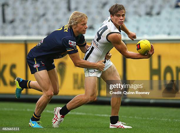 Josh Thomas of the Magpies handballs whislt being tackled by Isaac Heeney of Australia U18 during the AFL match between Australia U18 and the...