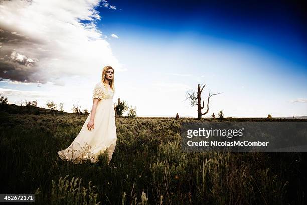 eerie young woman in white gown crossing american prairie brushland - lost angels stock pictures, royalty-free photos & images
