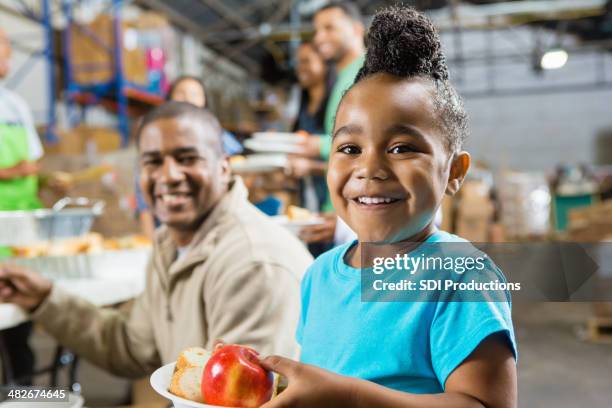 giovane ragazza con padre mangiare cibo sano alla mensa per i poveri - charity and relief work foto e immagini stock