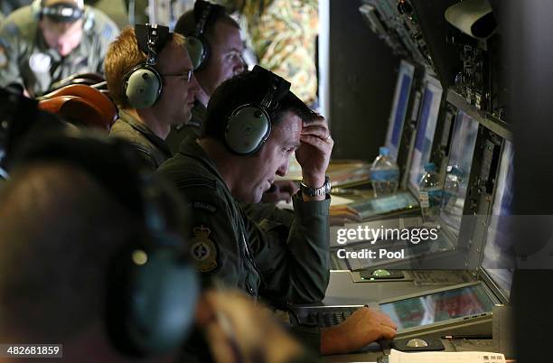 Operators monitor TAC stations onboard a RNZAF P3 Orion during search operations for wreckage and debris of missing Malaysia Airlines Flight MH370 in...