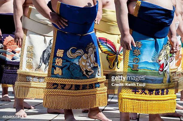 Professional sumo wrestlers with Kesho-mawashi large apron are seen during the Ceremonial Sumo Tournament or Honozumo at the Yasukuni Shrine on April...