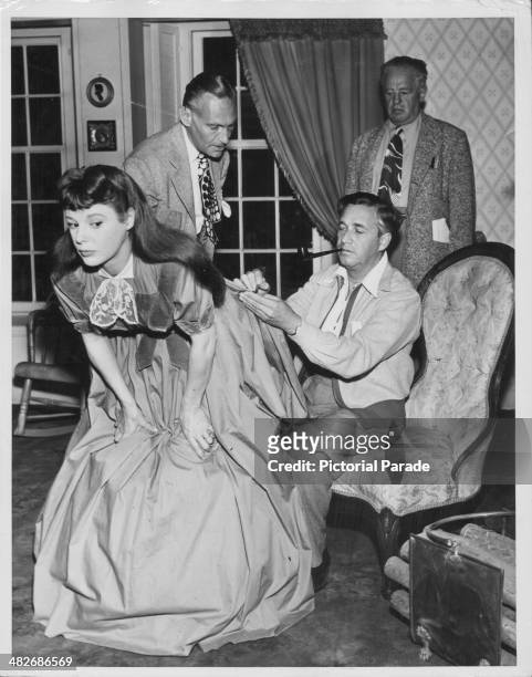 Director Mervyn LeRoy putting the finishing touches on to actress June Allyson's dress on the set of the movie 'Little Women', 1949.