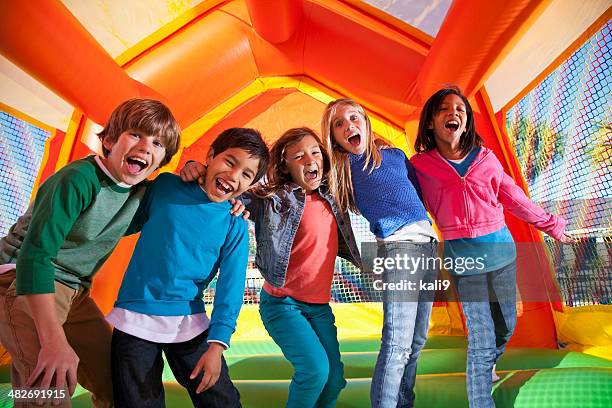 group of excited children in bouncy house - bouncing stockfoto's en -beelden