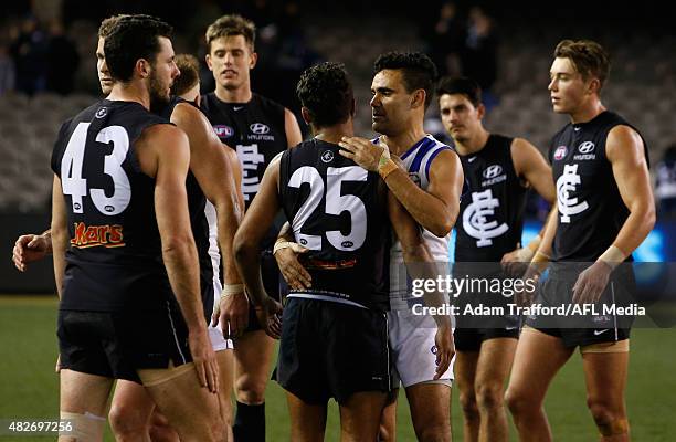 Lindsay Thomas of the Kangaroos hugs Clem Smith of the Blues after the 2015 AFL round 18 match between the Carlton Blues and the North Melbourne...
