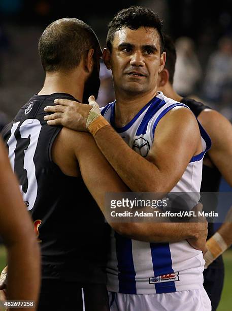 Lindsay Thomas of the Kangaroos hugs Chris Yarran of the Blues after the 2015 AFL round 18 match between the Carlton Blues and the North Melbourne...