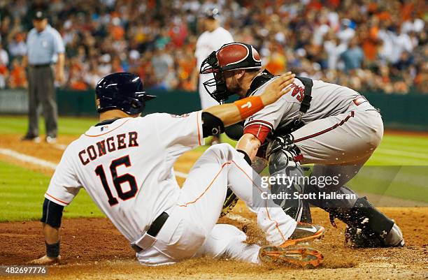 Hank Conger of the Houston Astros is tagged out at home plate by Jarrod Saltalamacchia of the Arizona Diamondbacks in the eighth inning during their...