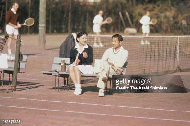 Crown Prince Akihito and Michiko Shoda talk while enjoying tennis at Tokyo Lawn Tennis Club on December 6, 1958 in Tokyo, Japan.