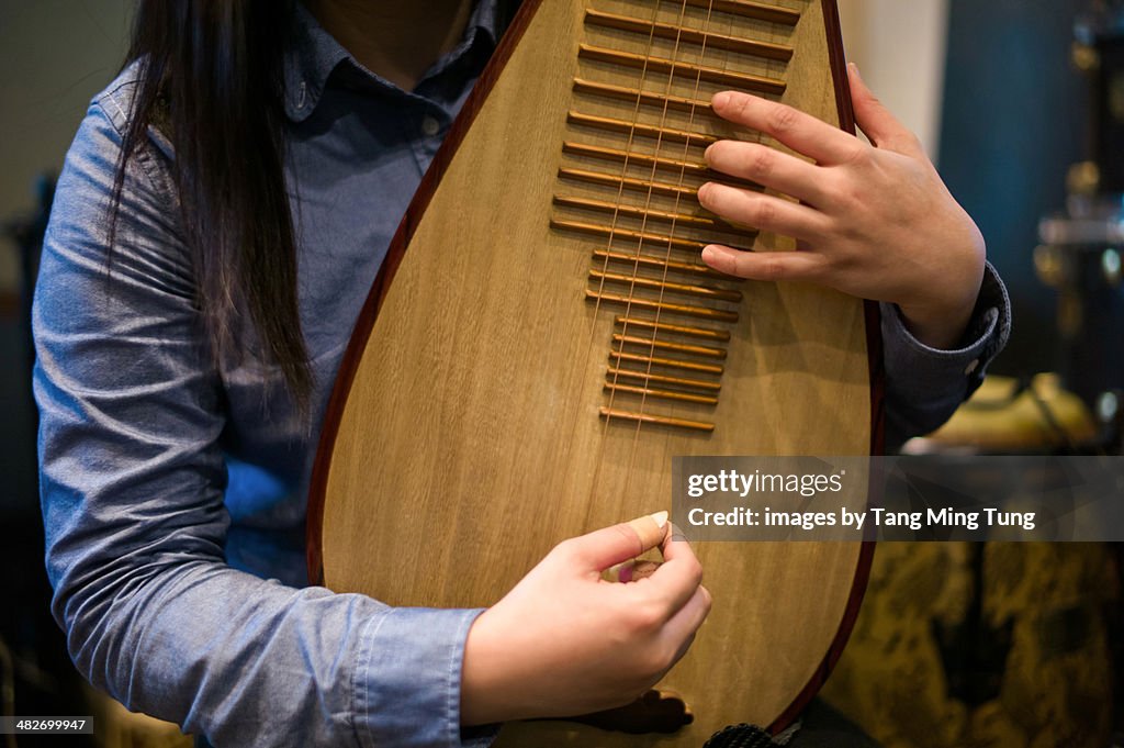 Young lady playing a Pipa