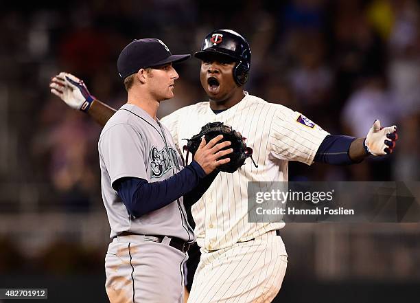 Miguel Sano of the Minnesota Twins celebrates a leadoff double as Brad Miller of the Seattle Mariners looks on during the ninth inning of the game on...