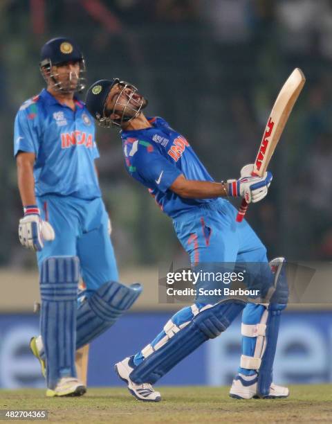 Virat Kohli of India screams after he hit the winning runs as MS Dhoni looks on as India win the ICC World Twenty20 Bangladesh 2014 2nd Semi-Final...